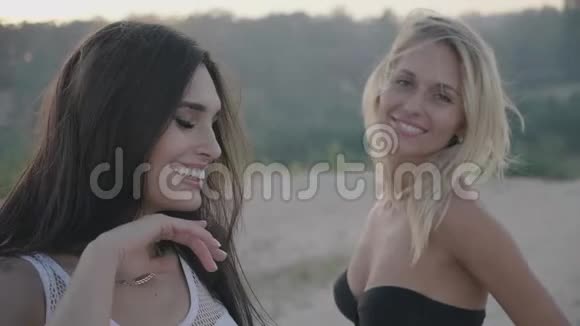 美丽的年轻女人黑发女人和她的金发朋友微笑着跳舞享受着假期的乐趣视频的预览图