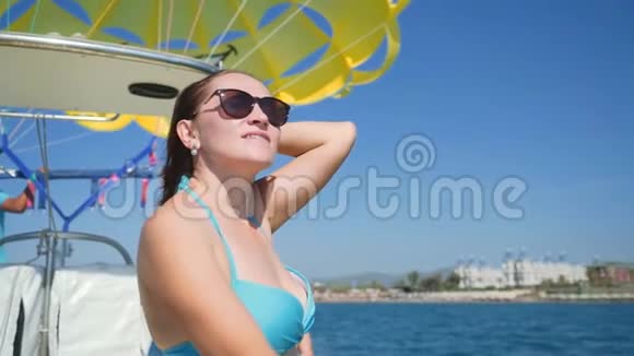 快乐的女人在海上的船上航行穿着蓝色泳衣的女人在船上视频的预览图