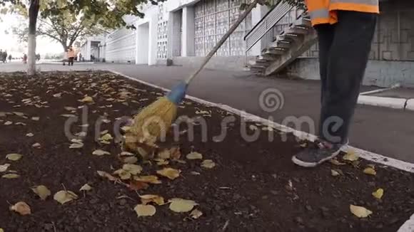 女看门人在秋天从树叶中清理公园这是最辛苦最低收入的工作视频的预览图