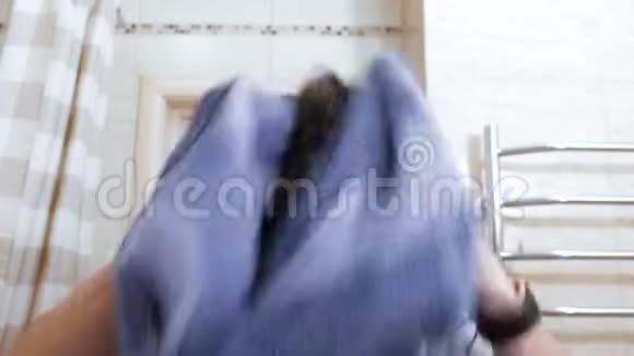 年轻的湿漉漉的男人用蓝色毛巾擦拭头发视频的预览图