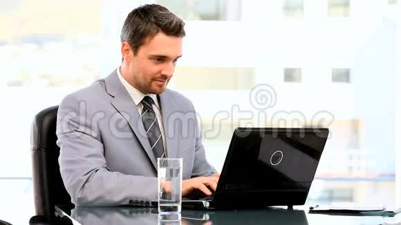 黑发商人在他的笔记本电脑上工作视频的预览图