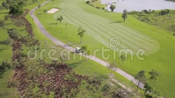 高尔夫球车在一流的高尔夫球场沿着赛道行驶在豪华高尔夫俱乐部度过美好的一天视频的预览图