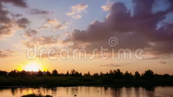 太阳在地平线上落下森林在河的上方夏季视频的预览图