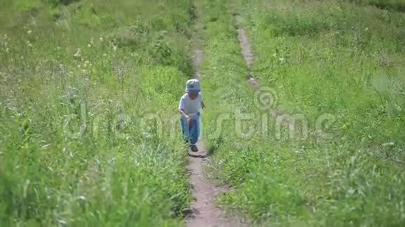 一个小男孩沿着森林里的一条狭窄的小路跑户外娱乐夏日炎炎视频的预览图