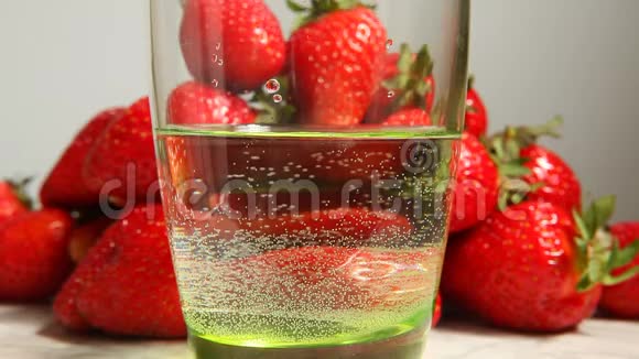 草莓在水中溅入玻璃中健康的食品理念视频的预览图