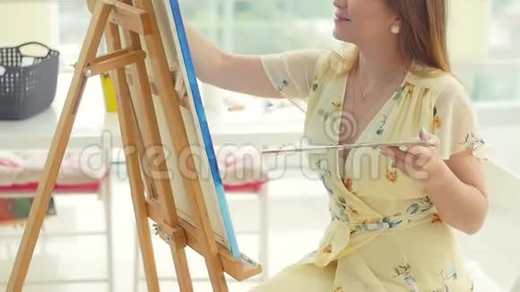 女艺术家在她的工作室工作创造美丽的图片用五颜六色的油画女画家在画视频的预览图