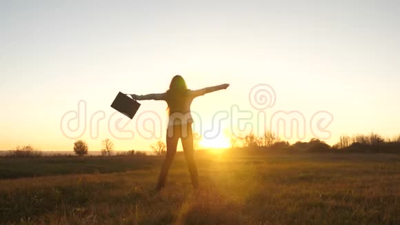 自由商务女性手里拿着公文包穿着商务套装在灿烂的阳光下在夕阳下取得了成功视频的预览图