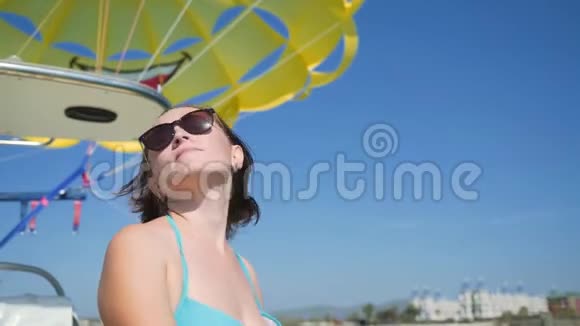 快乐的女人在海上的船上航行穿着蓝色泳衣的女人在船上视频的预览图