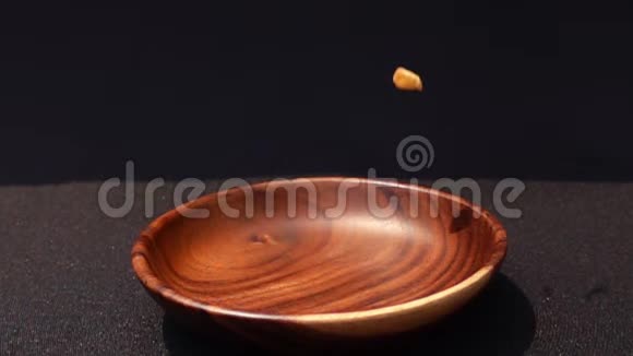 脆黄的玉米片落在黑底的木碗里视频的预览图