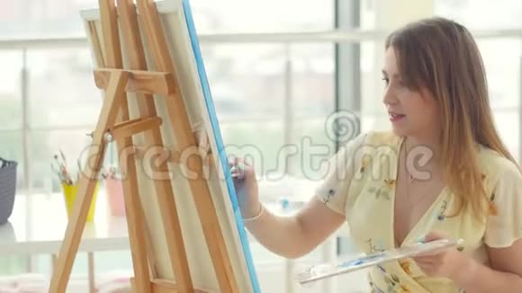 女艺术家在她的工作室工作创造美丽的图片用五颜六色的油画女画家在画视频的预览图