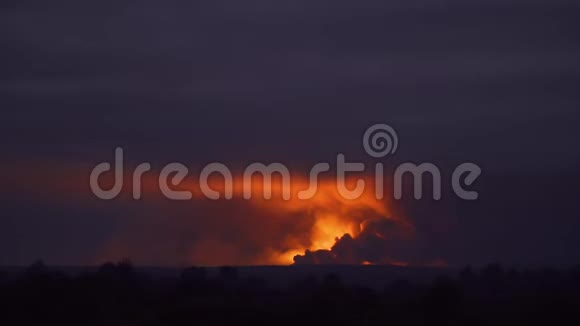 爆炸发出的明亮橙色光照亮了天空和周围的烟雾慢动作视频的预览图