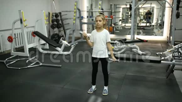 健身房里和哑铃订婚的小女孩视频的预览图