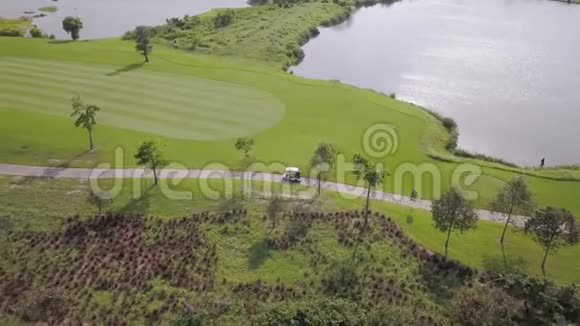 高尔夫球车沿着赛道行驶到下一个洞精英高尔夫俱乐部的精细鸟瞰图视频的预览图