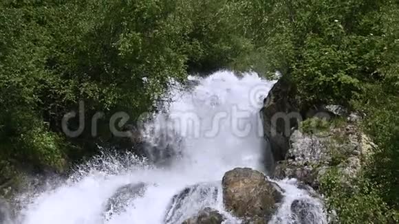 在一片绿色的森林中用跟踪线路缓慢地拍摄岩石和喷射暴风雨的山河概念视频的预览图