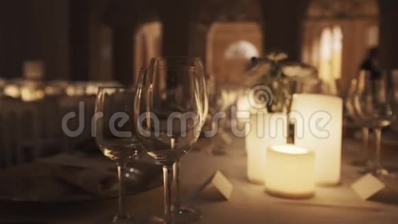 餐桌上摆放有点燃的蜡烛和餐盘的干净酒杯视频的预览图