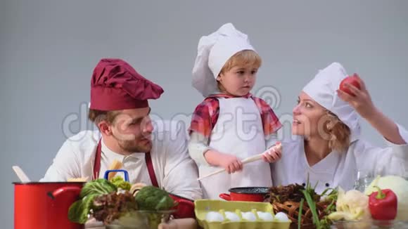 孩子们快乐的一天可爱的小男孩和他美丽的父母在厨房做饭时微笑年轻家庭视频的预览图
