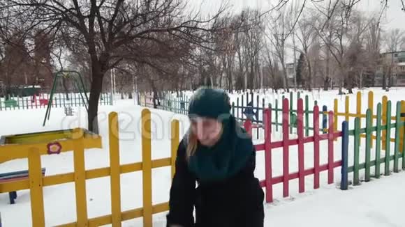 快乐的年轻女子在冬季公园里扔雪视频的预览图