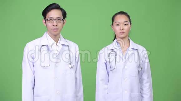 年轻的亚洲夫妇医生一起握手视频的预览图