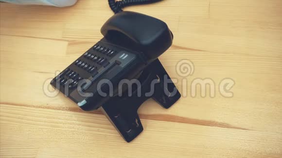年轻的商务女性拿着一台电话机按下按钮打电话靠近是黑色的视频的预览图