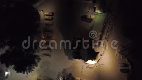 冬季夜间停车场的俯视图剪辑城市停车场冬季夜间有雪覆盖的汽车和明亮的灯光视频的预览图