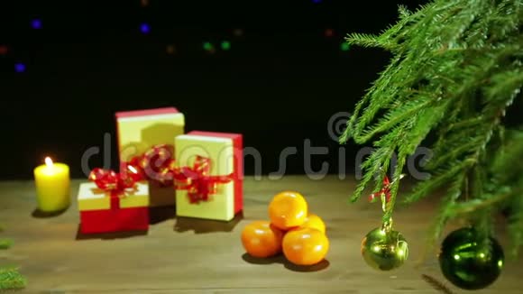 圣诞树旁边烛光下的圣诞盒子视频的预览图
