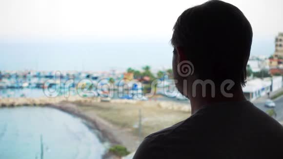 从露台欣赏海景的人剪影从阳台看码头的男性旅行者视频的预览图