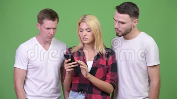 三个年轻朋友一起用电话听到坏消息视频的预览图