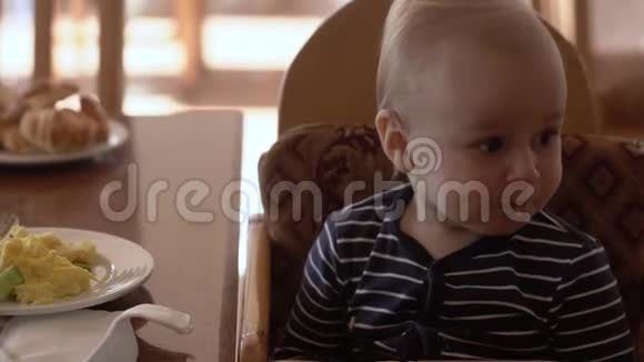 小婴儿坐在婴儿椅上吃食物视频的预览图