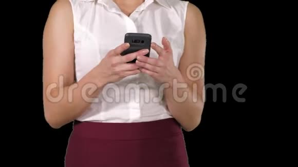 使用手机的漂亮女人用智能手机发短信阿尔法频道视频的预览图