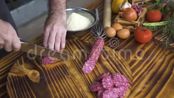 厨师在木板上切香肠双手合拢切香肠意大利香肠做披萨视频的预览图