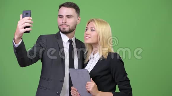 年轻的商业情侣在一起自拍时使用数码平板电脑视频的预览图