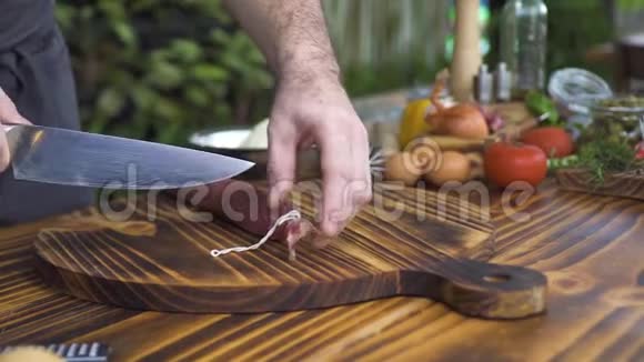 厨师切香肠在木板上贴紧男性手的烹饪切割香肠烹饪比萨饼流程视频的预览图