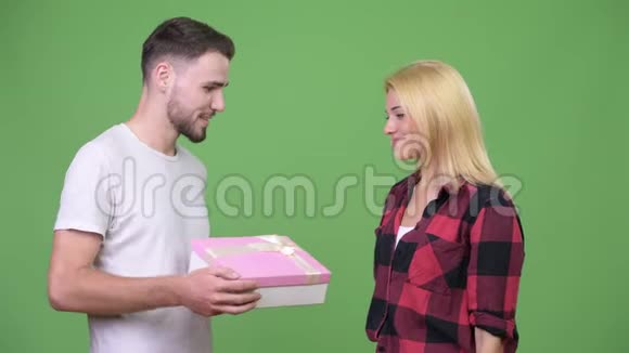 年轻人送礼物盒给年轻女人亲吻脸颊视频的预览图