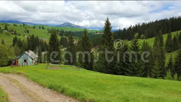 山景自然山上有一个古老的村庄有木制的小屋春日阳光明媚绿草如茵开着花视频的预览图