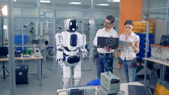 两名工程师正在用电脑遥控机器人的动作视频的预览图