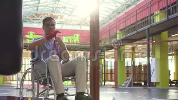 一个坐轮椅的残疾人在健身房的手上被拳击胶带伤了视频的预览图