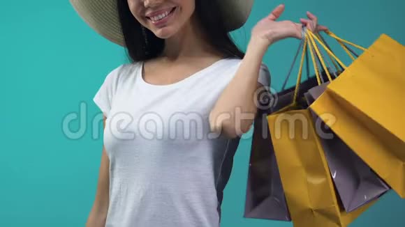 持有购物袋和信用卡的年轻女士购买出售视频的预览图