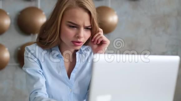 办公室里无聊的年轻女人拿着笔记本电脑盯着电脑屏幕视频的预览图