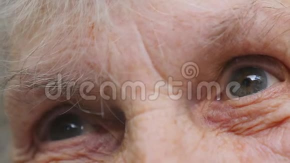 一位有皱纹的老太太的眼睛老妇人望着远处特写悲伤的肖像视频的预览图