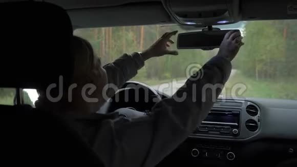 漂亮的女人在车里纠正后视镜视频的预览图