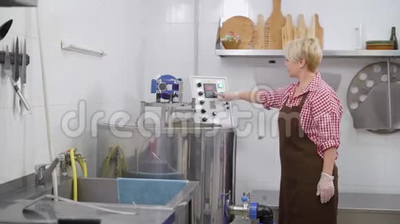 女技师正在设计一台白色房间里的自动迷你奶酪工厂机器并外出视频的预览图