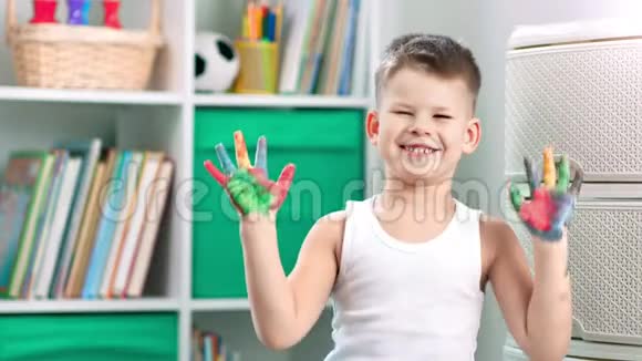 一个快乐的小男孩用手指画画视频的预览图