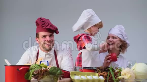 孩子们玩快乐游戏可爱的小男孩和他美丽的父母在厨房做饭时微笑年轻家庭视频的预览图