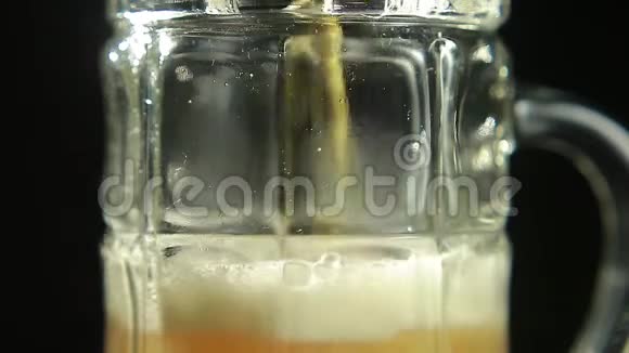 啤酒倒在一个黑色背景的杯子里视频的预览图