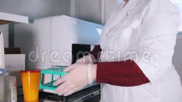 医疗诊所护士把血样放进机器里视频的预览图