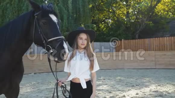 戴帽子的漂亮女孩带领黑马在竞技场上4K视频的预览图