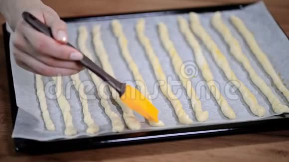 厨房里的女人用橄榄油刷格里西尼烹饪意大利格里西尼视频的预览图