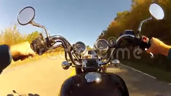 有人骑着摩托车在弯弯曲曲的森林山路上视频的预览图