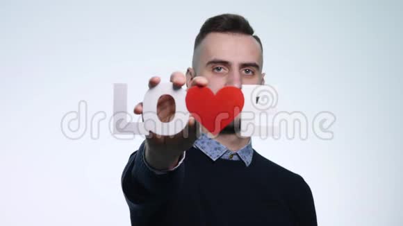 一个年轻人把爱情铭刻在白色背景上视频的预览图