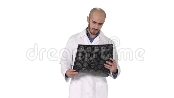 阿拉伯医生在白色背景下行走时检查MRI脑扫描视频的预览图